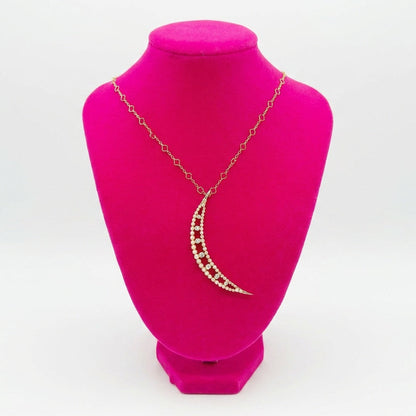Crescent moon pearl and diamond necklace on a pink mannequin bust with a white background