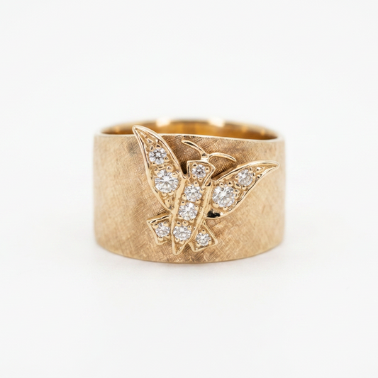 A textured yellow gold ring featuring a butterfly motif paved with small clear diamonds, set against a plain white background.