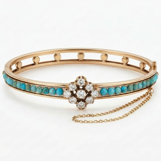 A gold bangle bracelet featuring a row of turquoise stones, a central floral cluster of clear diamonds, and a delicate gold safety chain, shown on a clean white background.