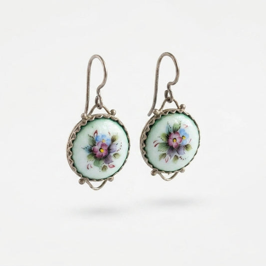 Pair of earrings with floral designs on a white background